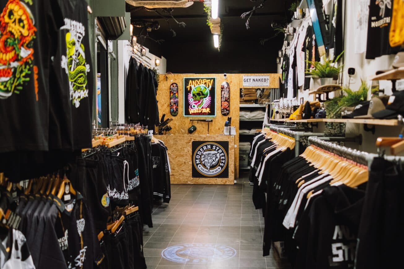 Inside the Modern Streets shop in Afflecks, Manchester, with rails of black printed tees and hoodies